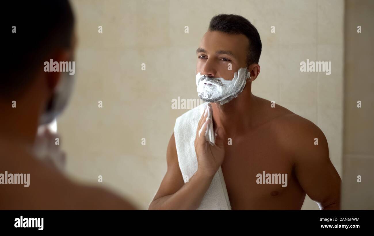 Man applying shaving cream to face and beard, ready to change appearance,  style Stock Photo - Alamy