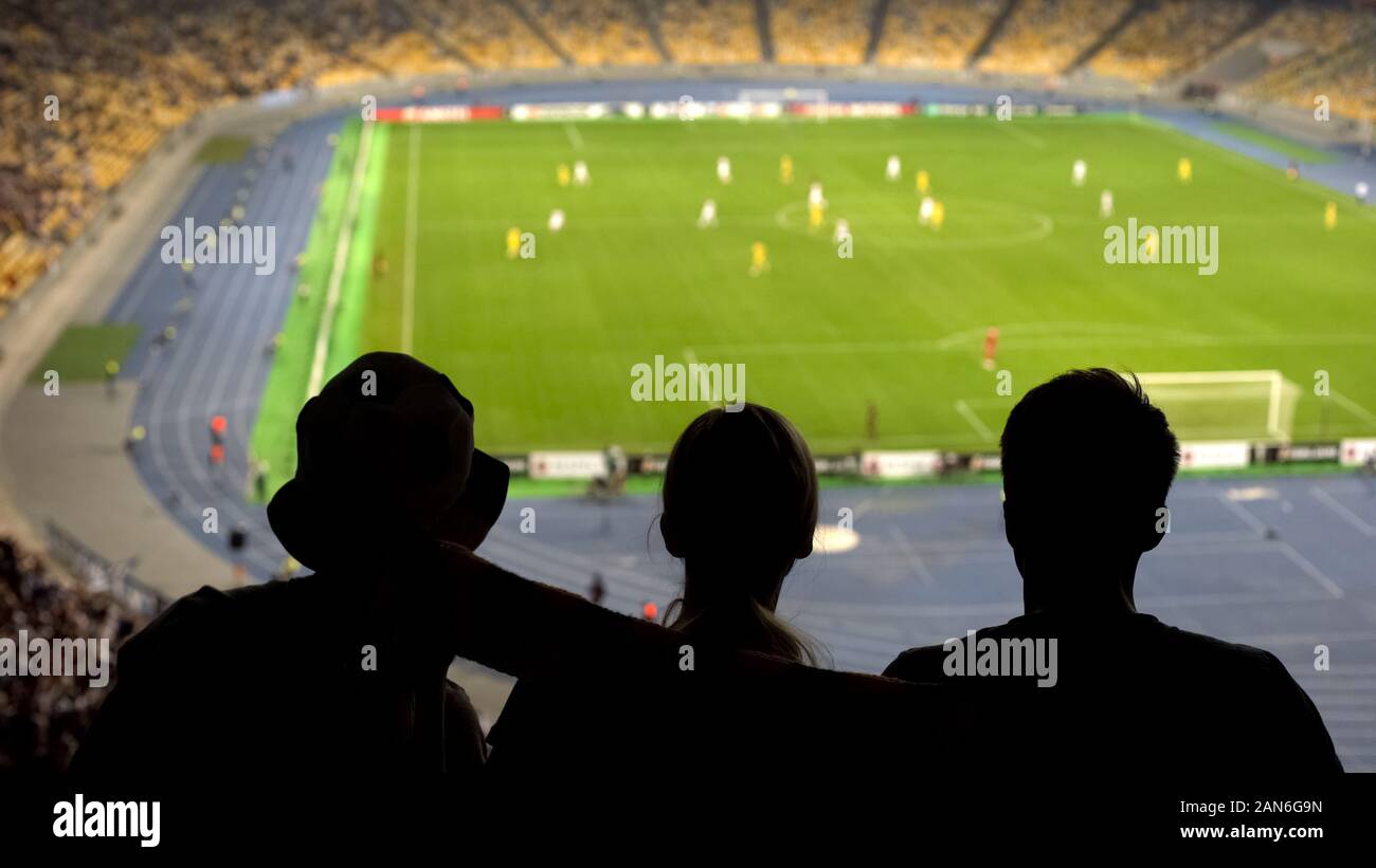 Concentrated fans looking at football pitch, dangerous moment, cheering