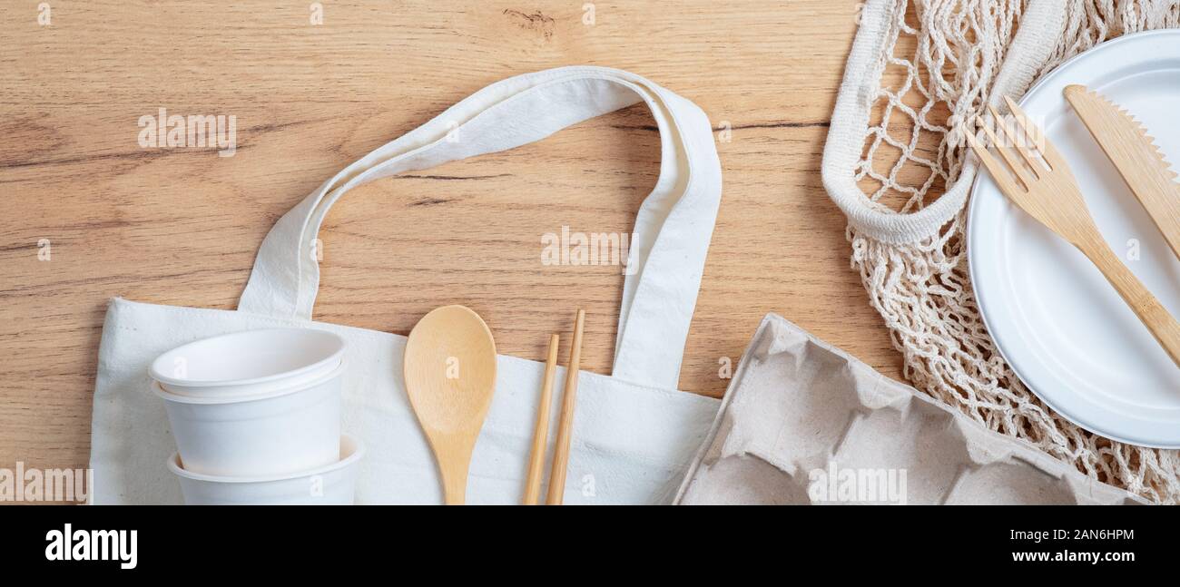 Top view eco-friendly utensils, bamboo cutlery, cotton and string shopping bags, carton eggs box on wooden table. Sustainable lifestyle. Zero waste, p Stock Photo