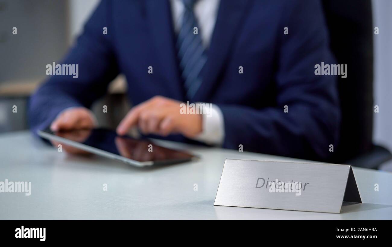 Serious company director using tablet pc on workplace, checking important files Stock Photo