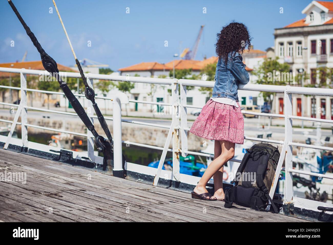 White woman looking at the city view from a ship deck Stock Photo