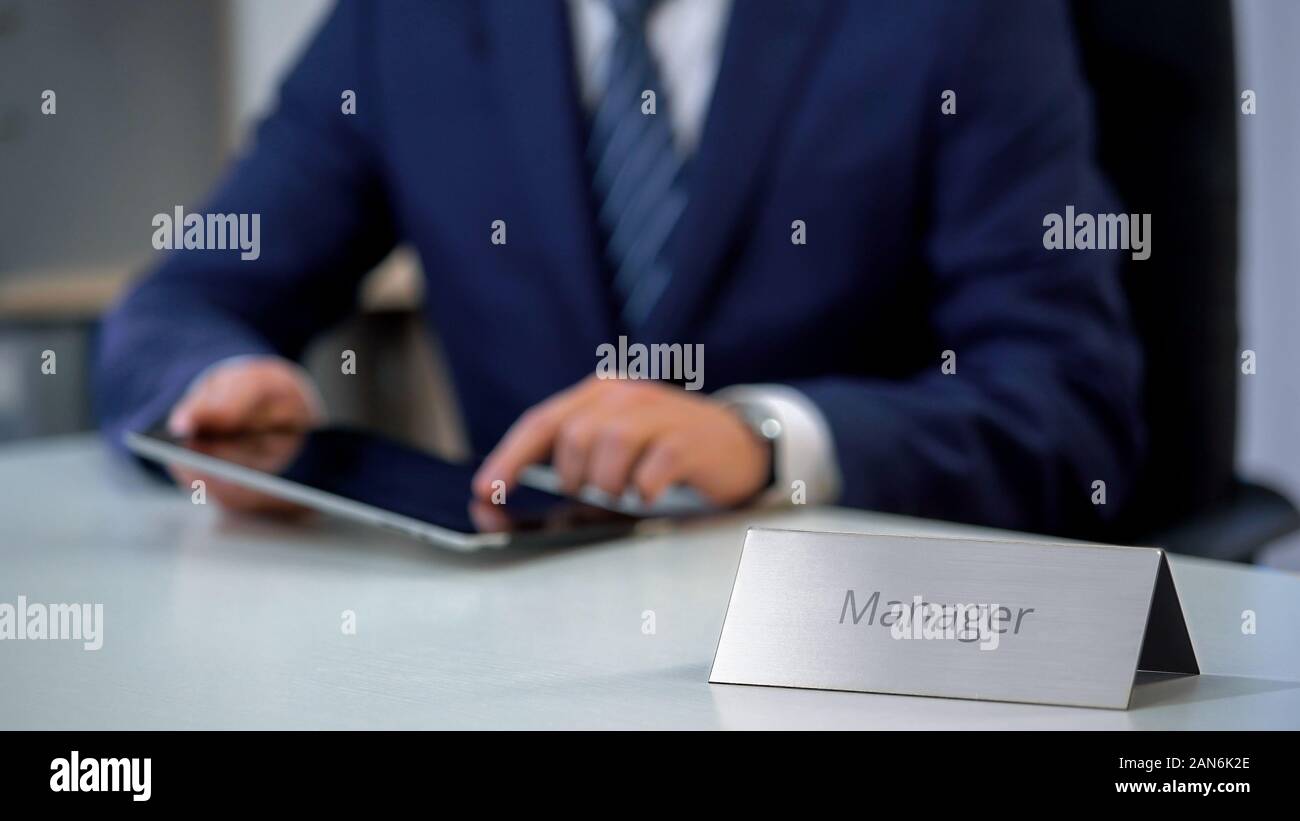 Young business manager working on project online, using tablet computer Stock Photo