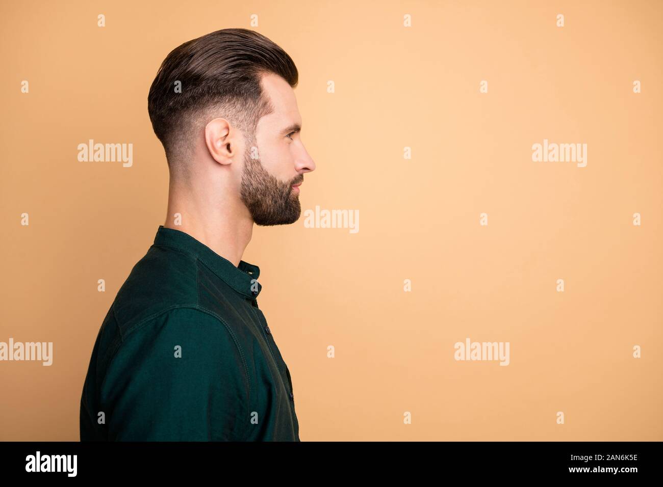 Closeup profile photo of macho guy serious looking empty space perfect neat hairstyle bristle young responsible boss wear casual outfit isolated beige Stock Photo -
