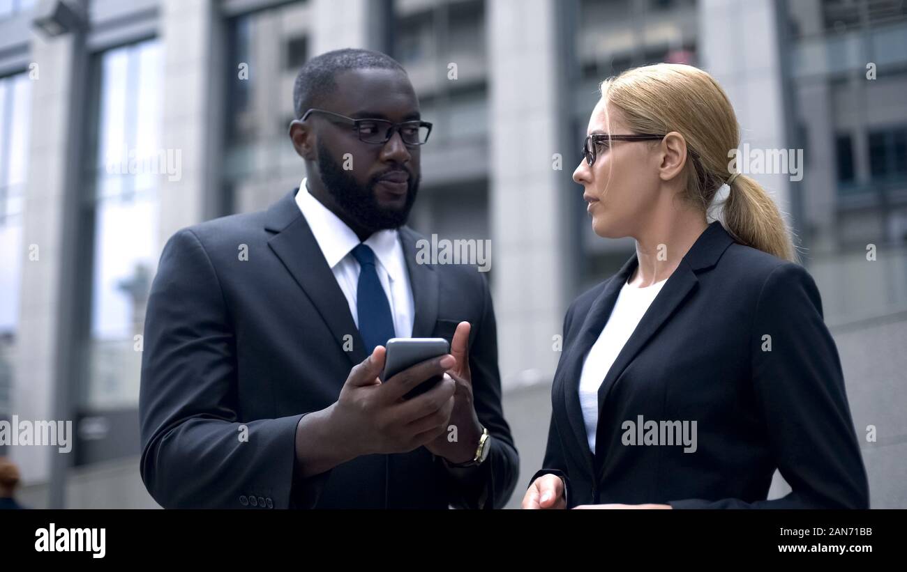 Office workers using smartphone, texting with business partner, checking e-mail Stock Photo