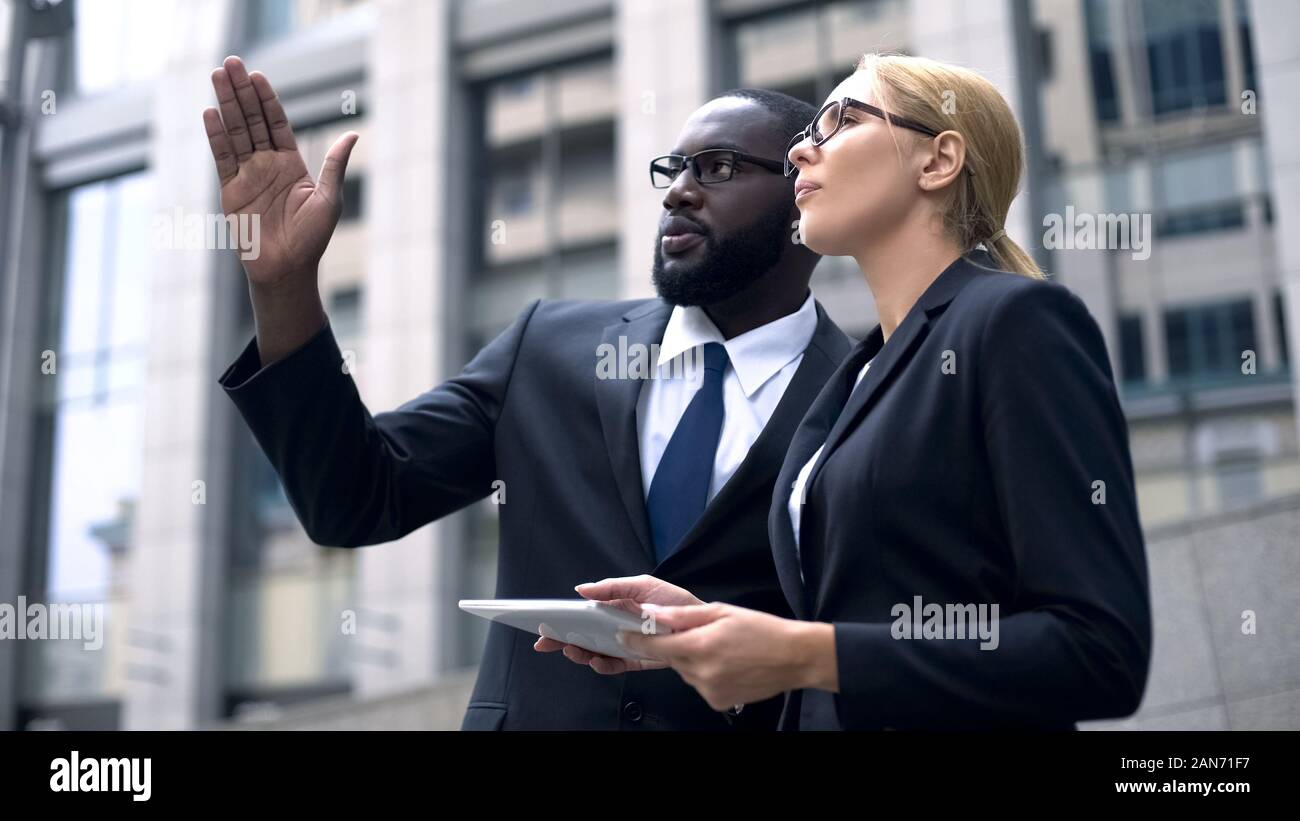 Business team of engineers discussing architectural design, using digital tablet Stock Photo