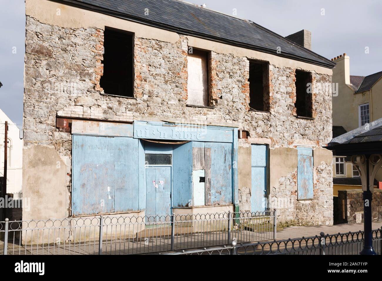 CONWY, UK - February 26, 2012. Abandoned local shop on a high street in Wales, with boarded up windows Stock Photo