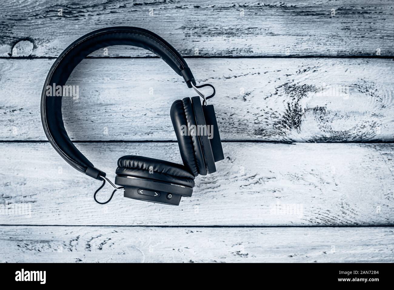 Black headphones on a gray wooden background. Layout, text space. Music lifestyle Stock Photo