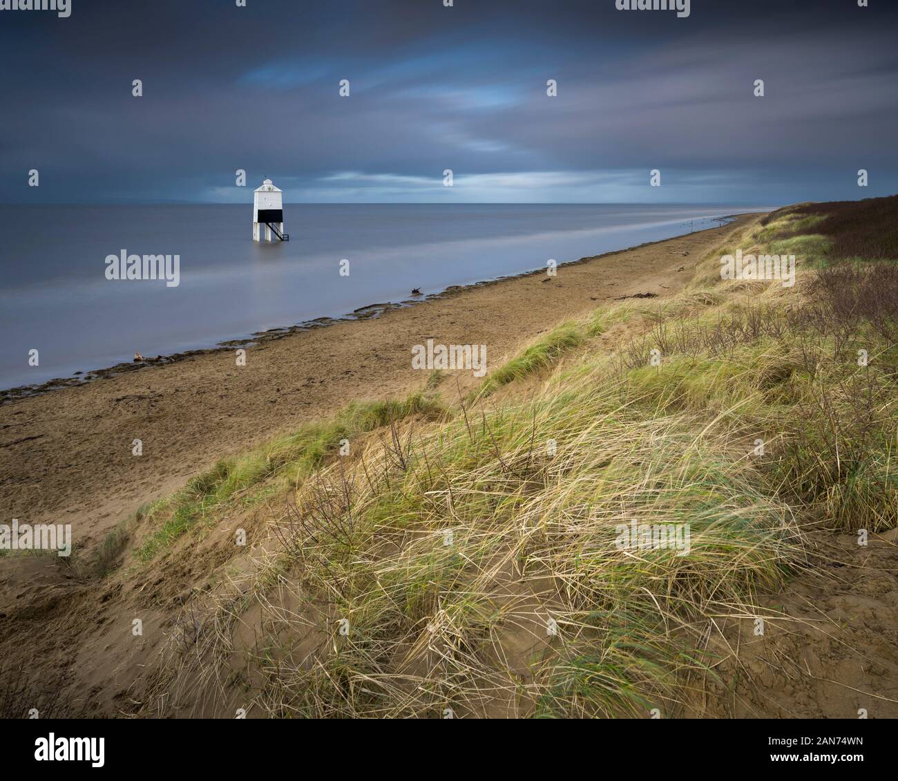 The sand dunes and the low lighthouse on the beach at Burnham-on-Sea, Somerset, England. Stock Photo