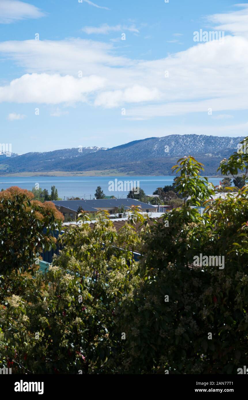 Lake Jindabyne, Jindabyne township and surrounding mountains covered in a dusting of snow after a late spring snowstorm Stock Photo