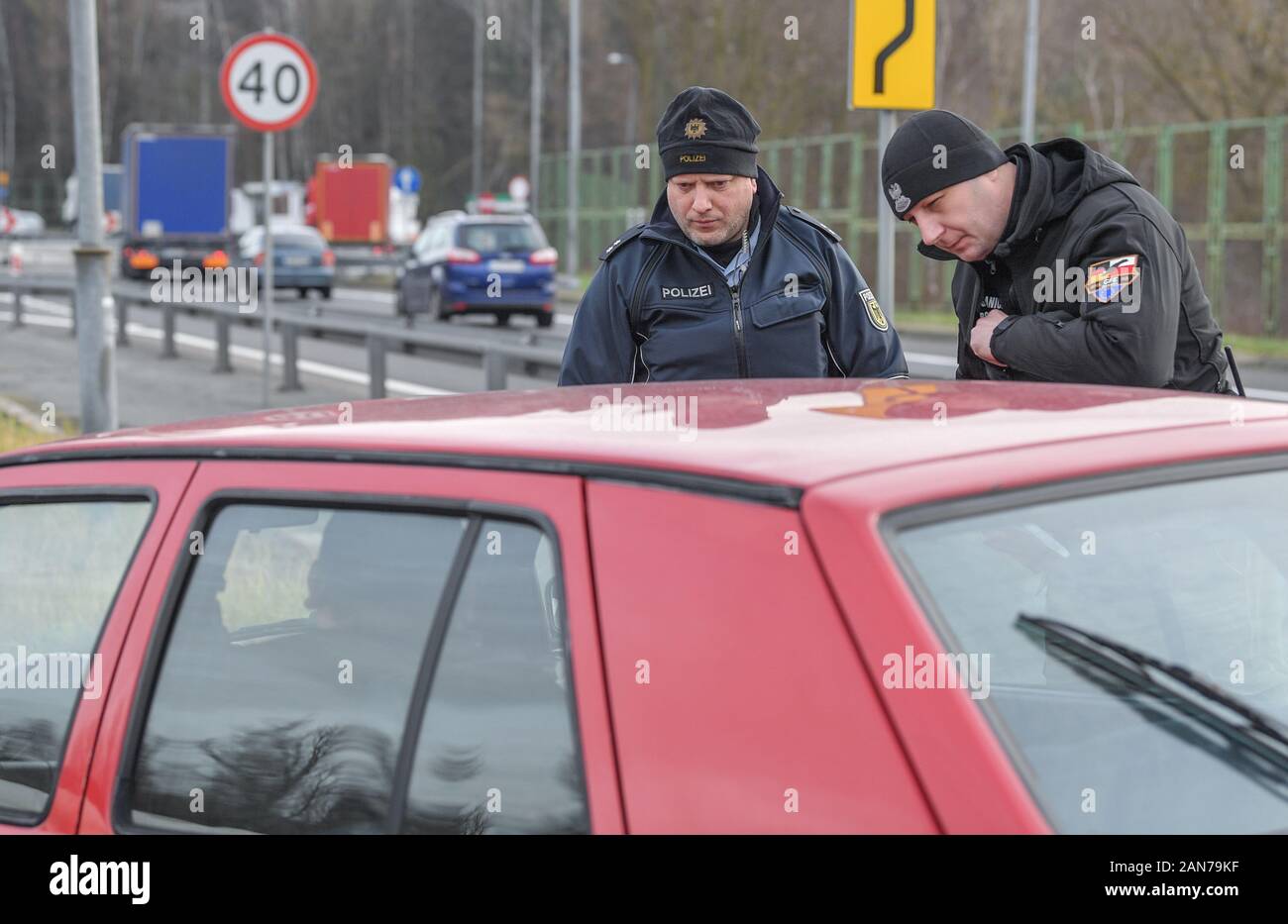 14 January 2020, Brandenburg, Frankfurt (Oder): Sven Umland (l), Senior Police Commissioner at the Federal Police and Damian Kuzynin, from the Polish Border Guard, check travellers in a car on Autobahn 12 shortly before the Polish border. German and Polish border guards are patrolling the Oder and Neisse rivers together, and since the autumn they have also been patrolling in new official vehicles. Nevertheless, the fight against transnational crime remains arduous, not least because of the density of traffic. Photo: Patrick Pleul/dpa-Zentralbild/ZB Stock Photo