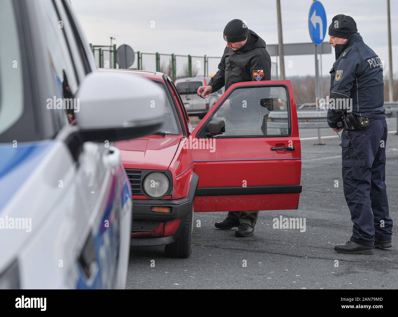 14 January 2020, Brandenburg, Frankfurt (Oder): Sven Umland (r), Senior Police Commissioner at the Federal Police and Damian Kuzynin, from the Polish Border Guard, check travellers in a car on Autobahn 12 shortly before the Polish border. German and Polish border guards are patrolling the Oder and Neisse rivers together, and since the autumn they have also been patrolling in new official vehicles. Nevertheless, the fight against transnational crime remains arduous, not least because of the density of traffic. Photo: Patrick Pleul/dpa-Zentralbild/ZB Stock Photo