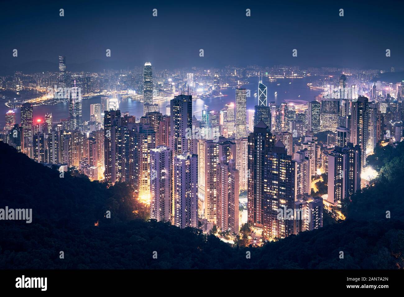 Hong Kong city skyline at night. Cityscape with skyscrapers against traffic in Victoria Harbour. Stock Photo