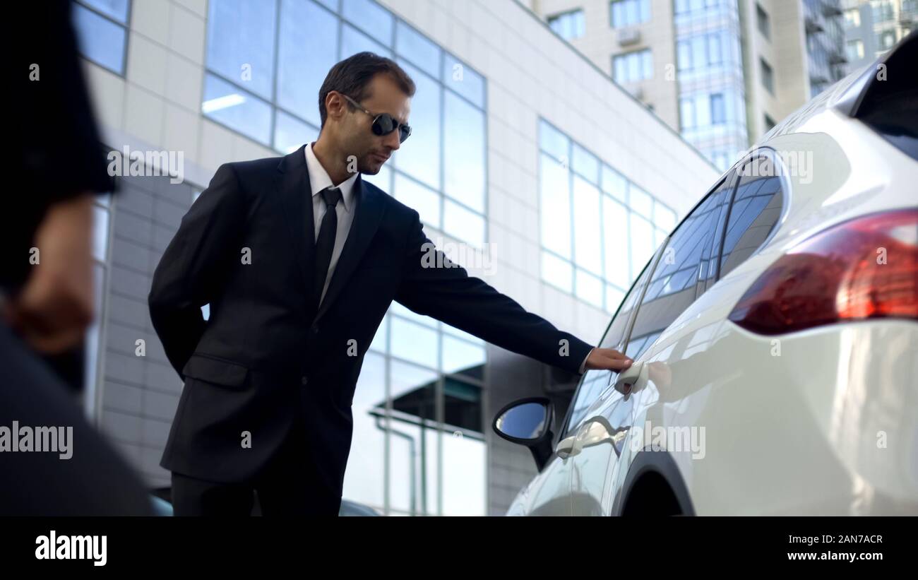 Personal driver meeting and opening car door for lady boss, bodyguard duties Stock Photo - Alamy