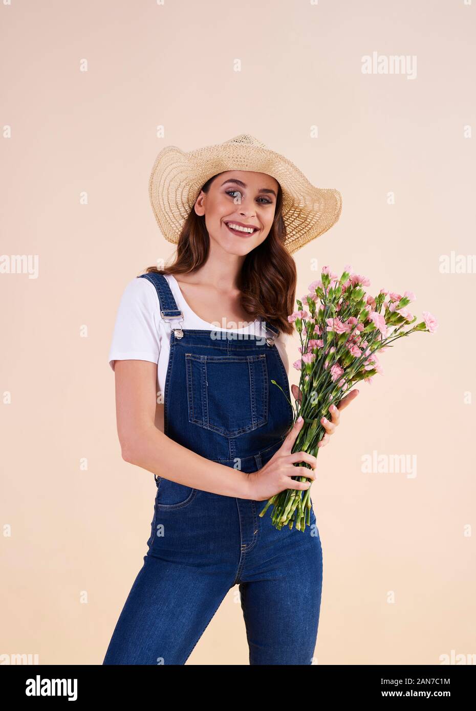 Portrait of smiling woman with bunch of flowers Stock Photo