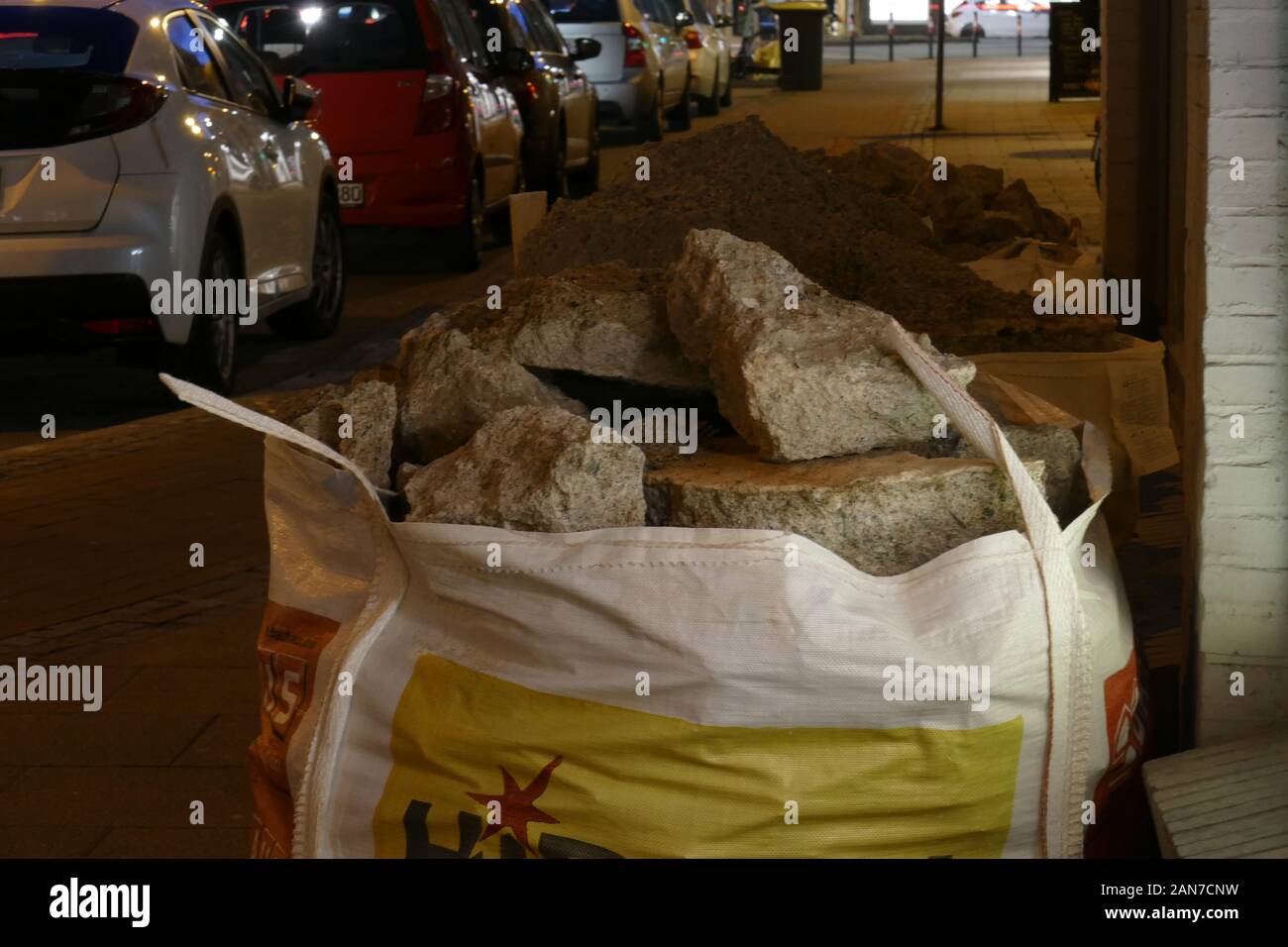 Garbage bags filled with rubble standing on the street at night, Germany, Europe Stock Photo