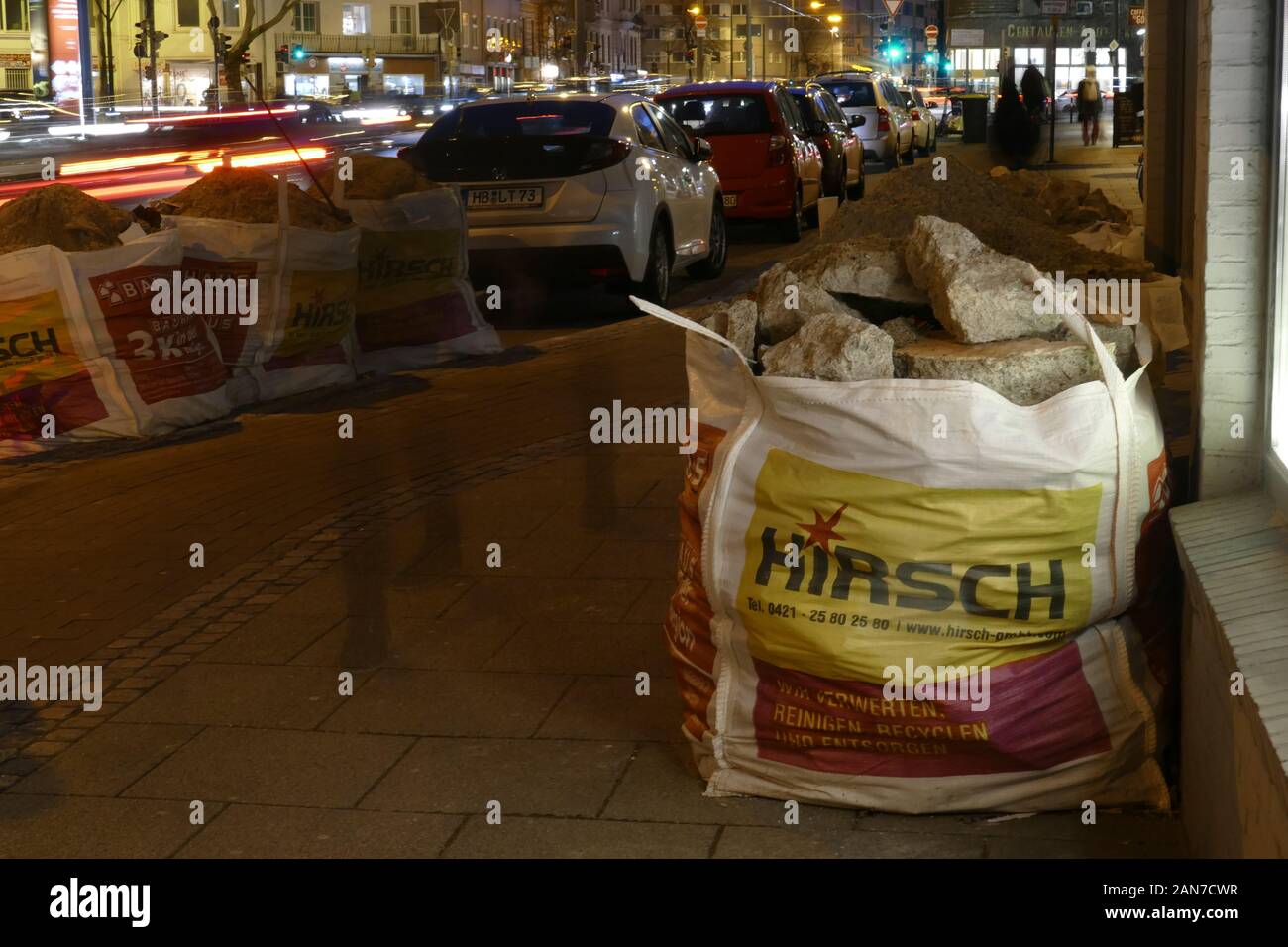 Garbage bags filled with rubble standing on the street at night, Germany, Europe Stock Photo