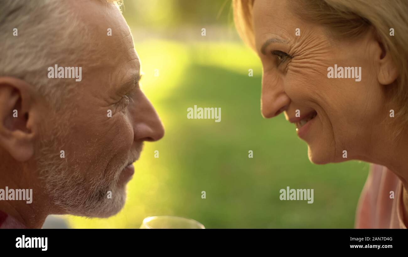 Smiling elderly couple looking at each other with love and tenderness ...