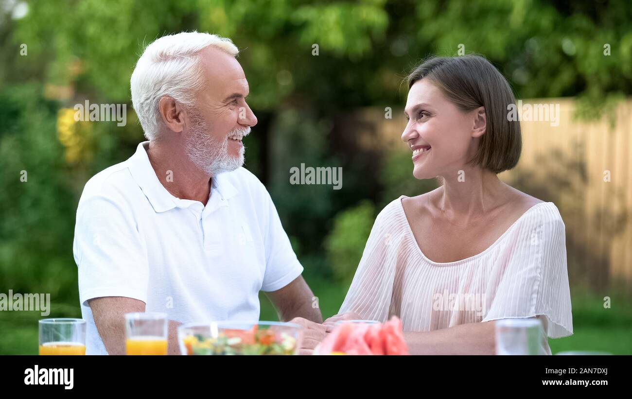 Daughter-in-law talking to father-in-law, respectful relations and understanding Stock Photo