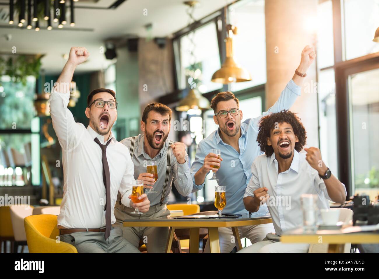 business people cheering on beer. Business people watch the game and cheer for their team Stock Photo