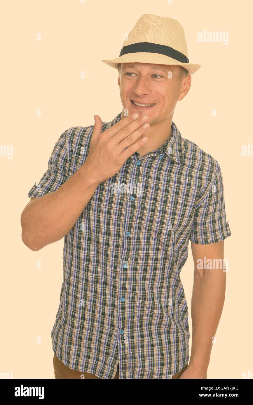 Studio shot of young happy Caucasian man giggling isolated against white background Stock Photo