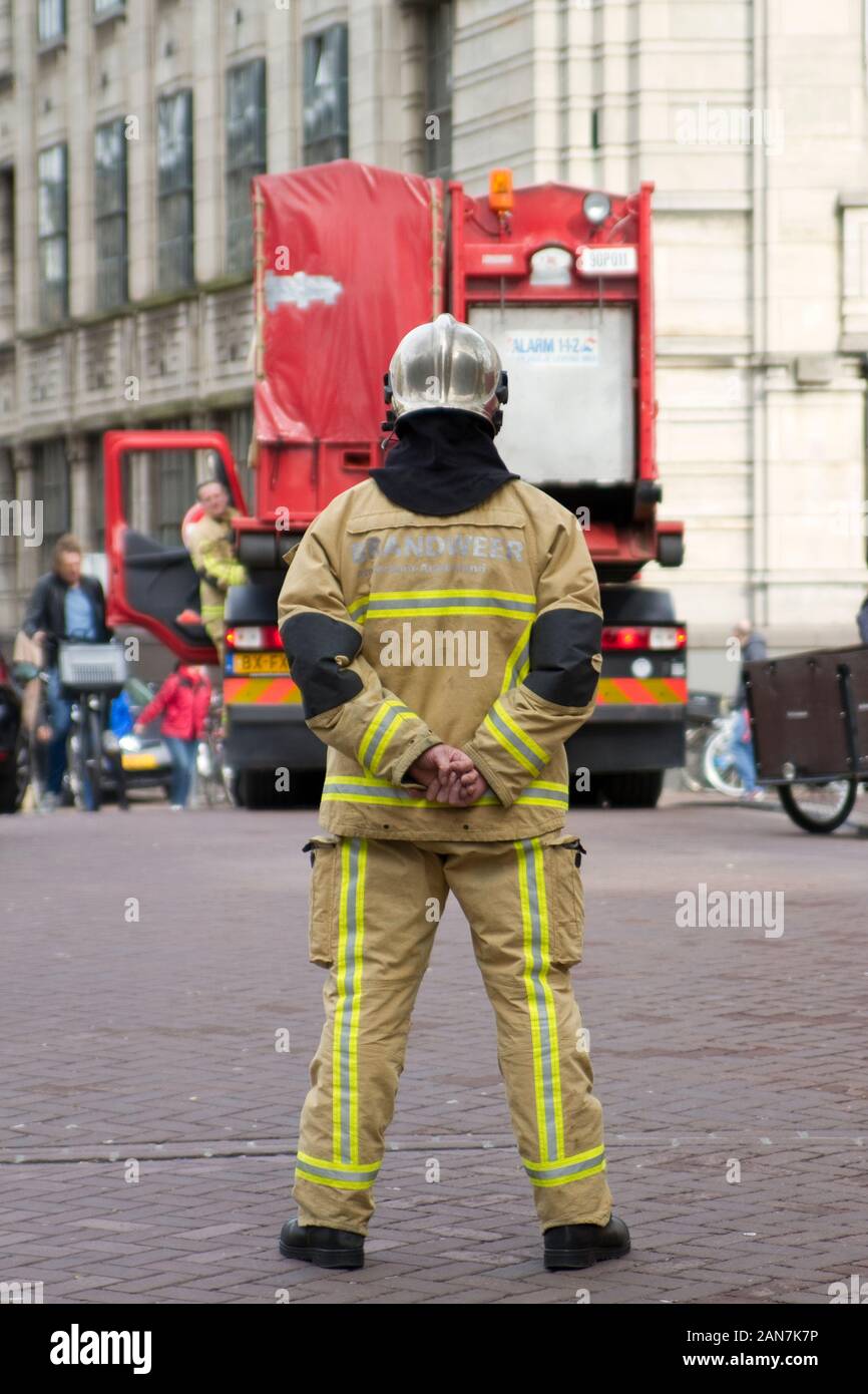A local fireman is monitoring the situation during a rescue operation by the Amsterdam fire Department in 2016. Stock Photo