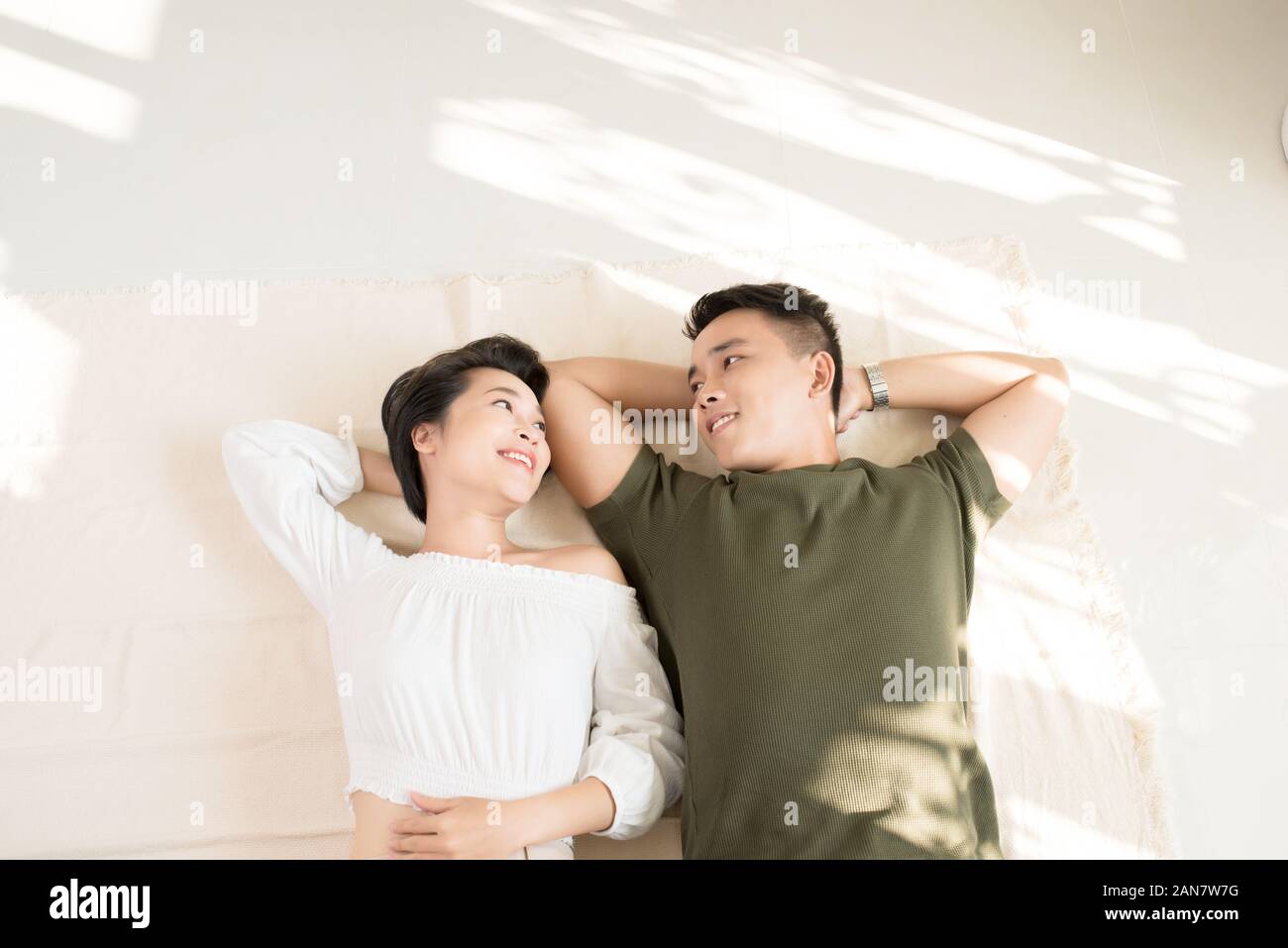Beautiful Asian couple lying on floor Stock Photo - Alamy