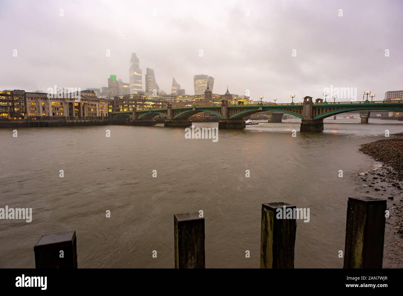 The tops of City of London skyscrapers obscured by low cloud during a wet winter day in London, England Stock Photo