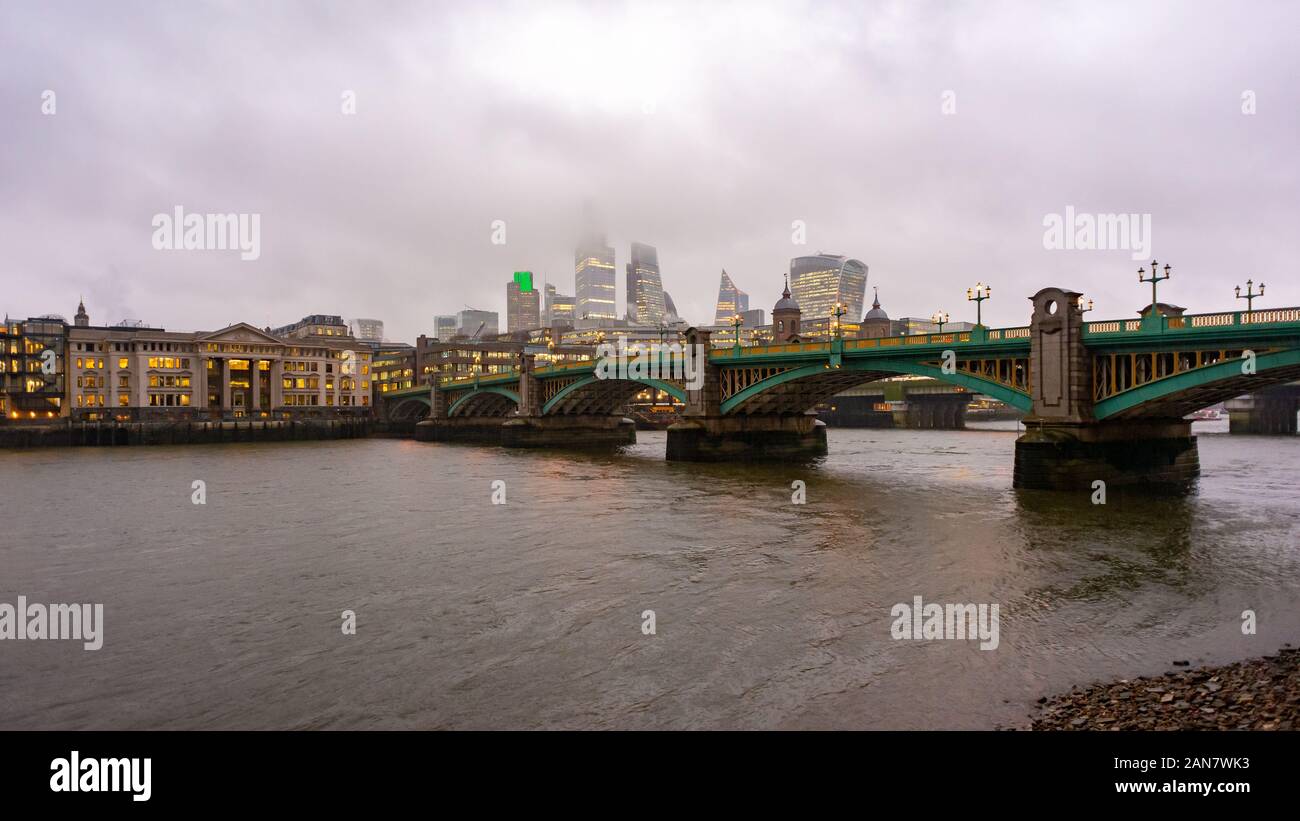 The tops of City of London skyscrapers obscured by low cloud during a wet winter day in London, England Stock Photo