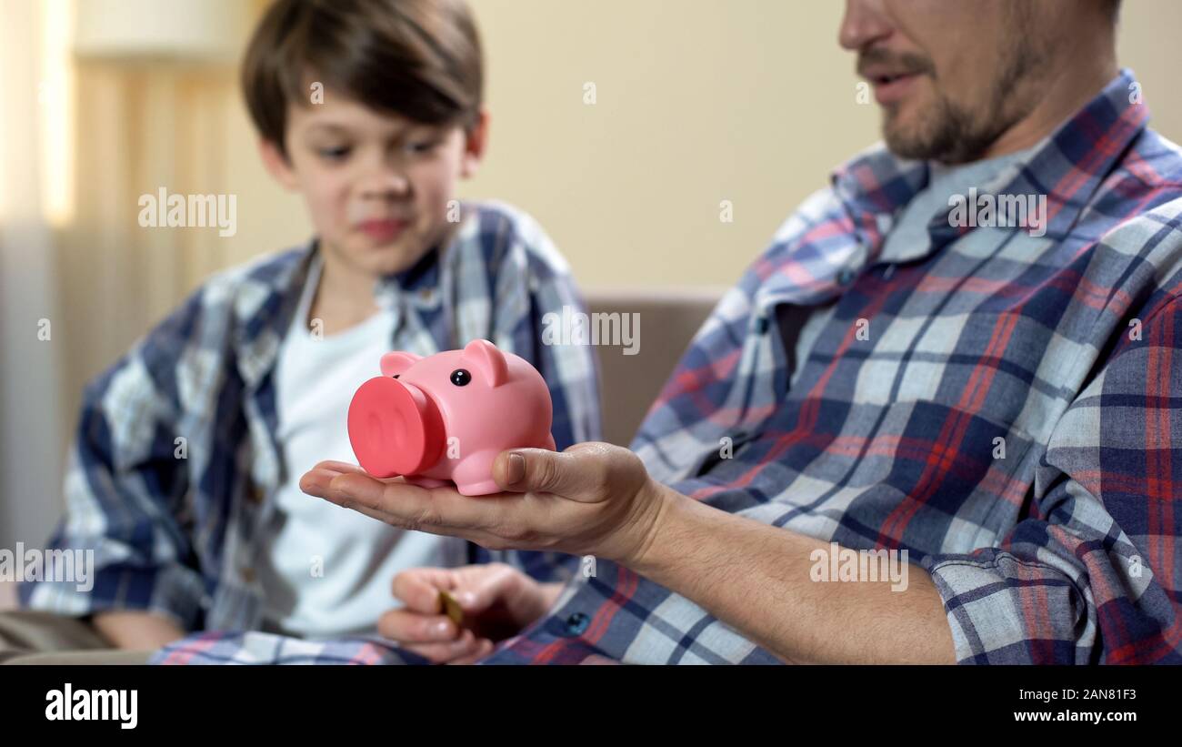 Father and son putting coin piggy bank hi-res stock photography and ...