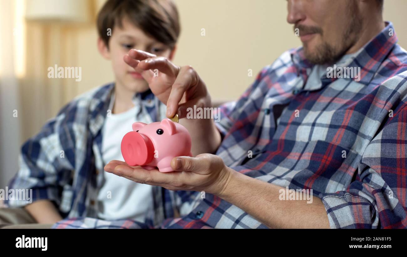Father and son putting coin piggy bank hi-res stock photography and ...