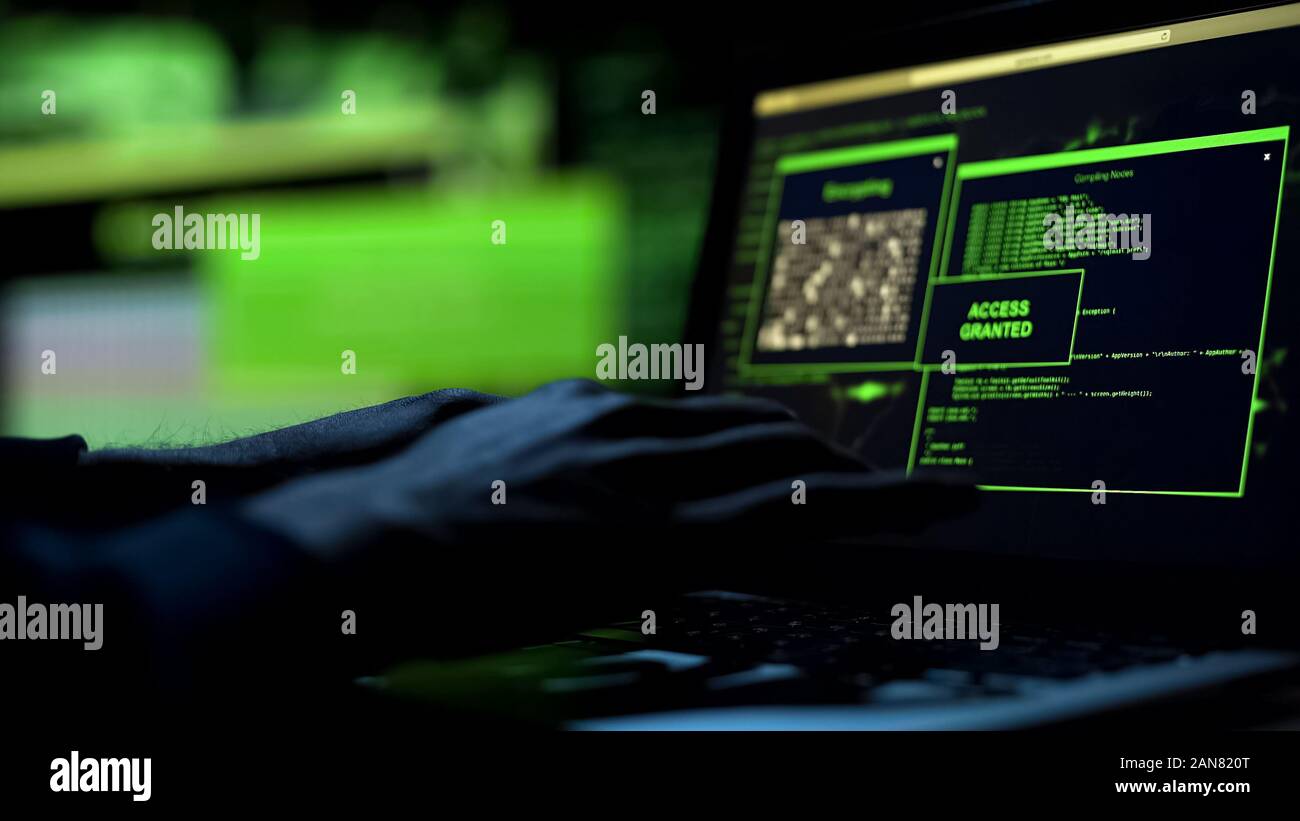 Close-up hacker hands working on laptop, selecting password, access granted Stock Photo