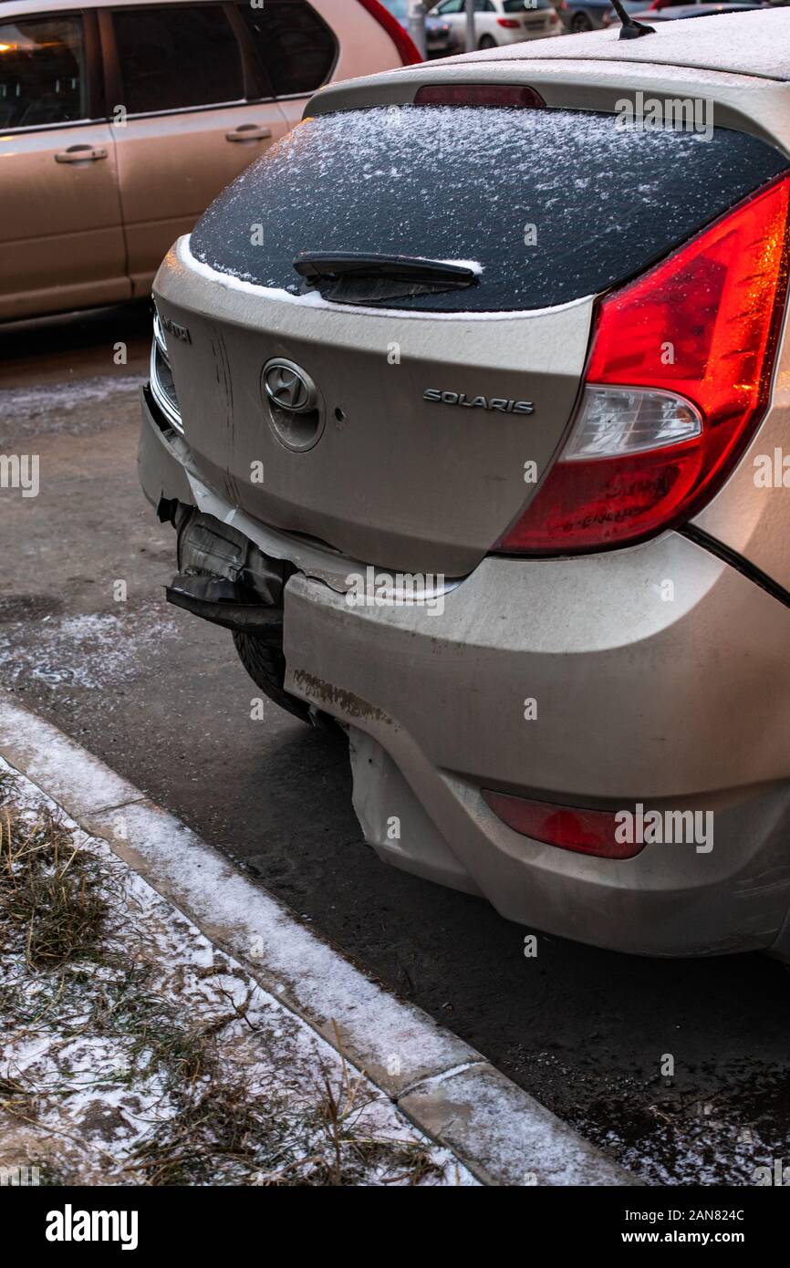 Moscow, Russia - December 29, 2019: Hyundai Solaris car after the accident, broken bumper vertical close-up. Broken Hyundai, a Korean car with a torn Stock Photo