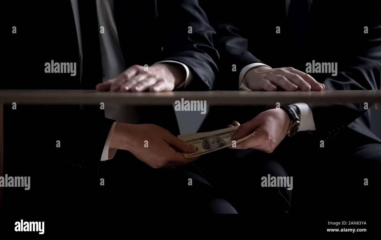 Politician hands taking bribe money under office table, lobbying of interests Stock Photo