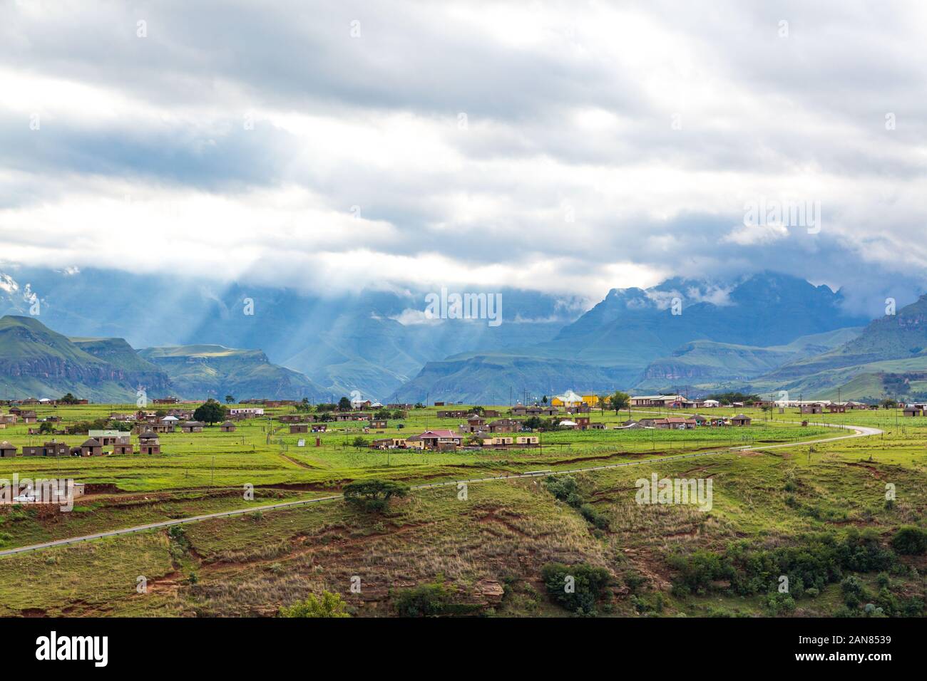 Village in the mountains of Maloti Drakensberg Park with sunbeams breaking through the clouds, South Africa Stock Photo