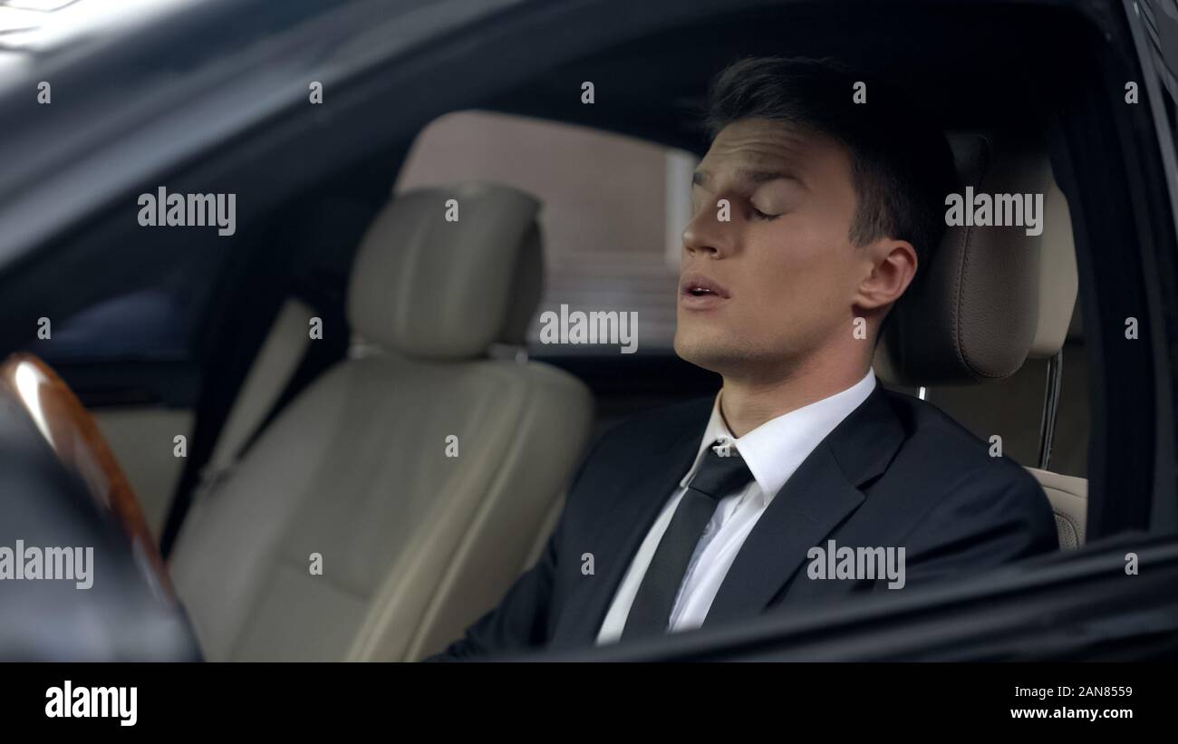 Sleepy business person sitting in car, sleeping disorder, stressful lifestyle Stock Photo