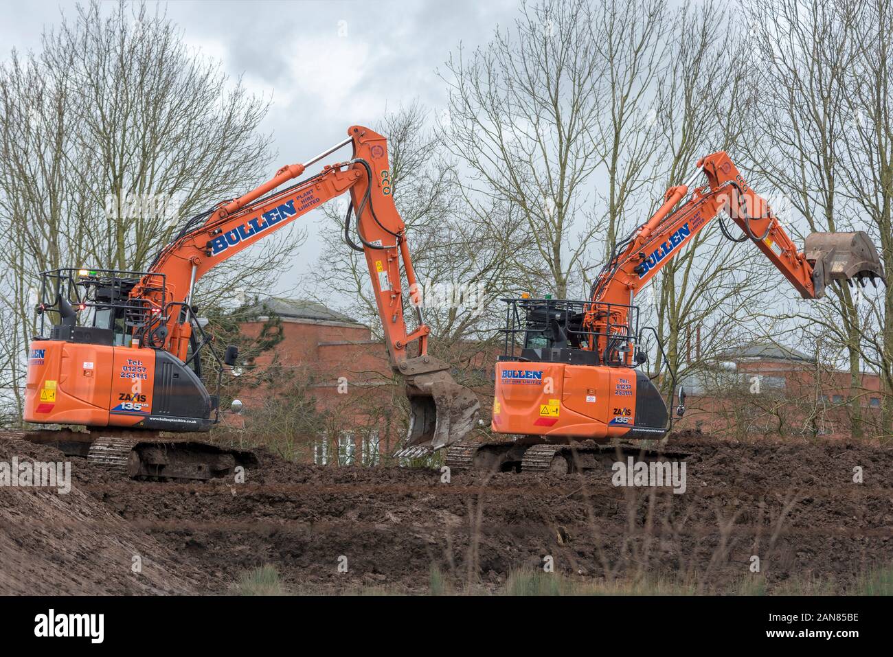 https://c8.alamy.com/comp/2AN85BE/looking-like-dinosaurs-two-diggers-at-work-on-building-site-company-name-bullens-2AN85BE.jpg