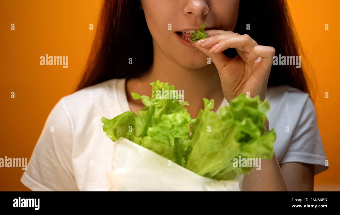 Happy girl eating lettuce, vegetarian eco products