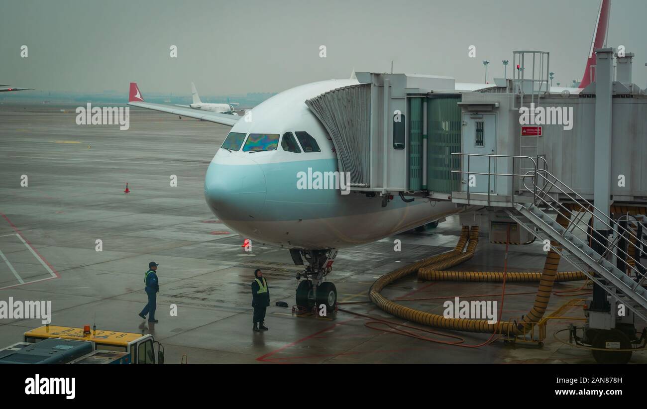 Shanghai, China - January 28, 2019: Airplane ready for boarding in Shanghai airport hub on rainy day Stock Photo