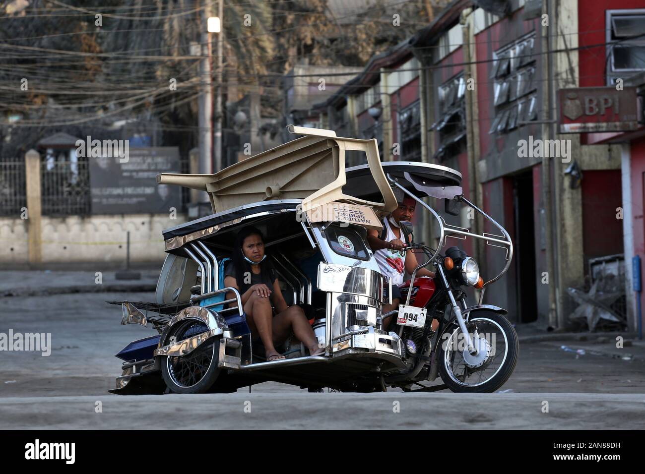 Talisay, Philippines. 16th Jan, 2020. A married couple transports their belongings on a tricycle in Talisay, in the province of Batangas. The Taal volcano lost some activity on Thursday, the fifth day of eruption, but the risk of a dangerous lava eruption remains, according to the Philippine Institute of Volcanology and Seismology (Phivolcs). Around 70,000 people are being evacuated in the provinces of Batangas and Cavite because it is still not safe to stay in the 14-kilometre danger zone around the Taal. Credit: Alejandro Ernesto/dpa/Alamy Live News Stock Photo