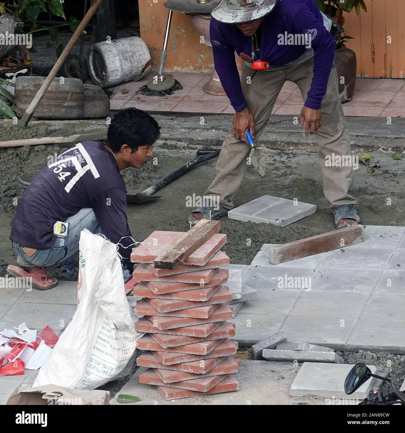 Bangkok, Thailand - December 25, 2019: Construction site. Men install new pavement. Stock Photo