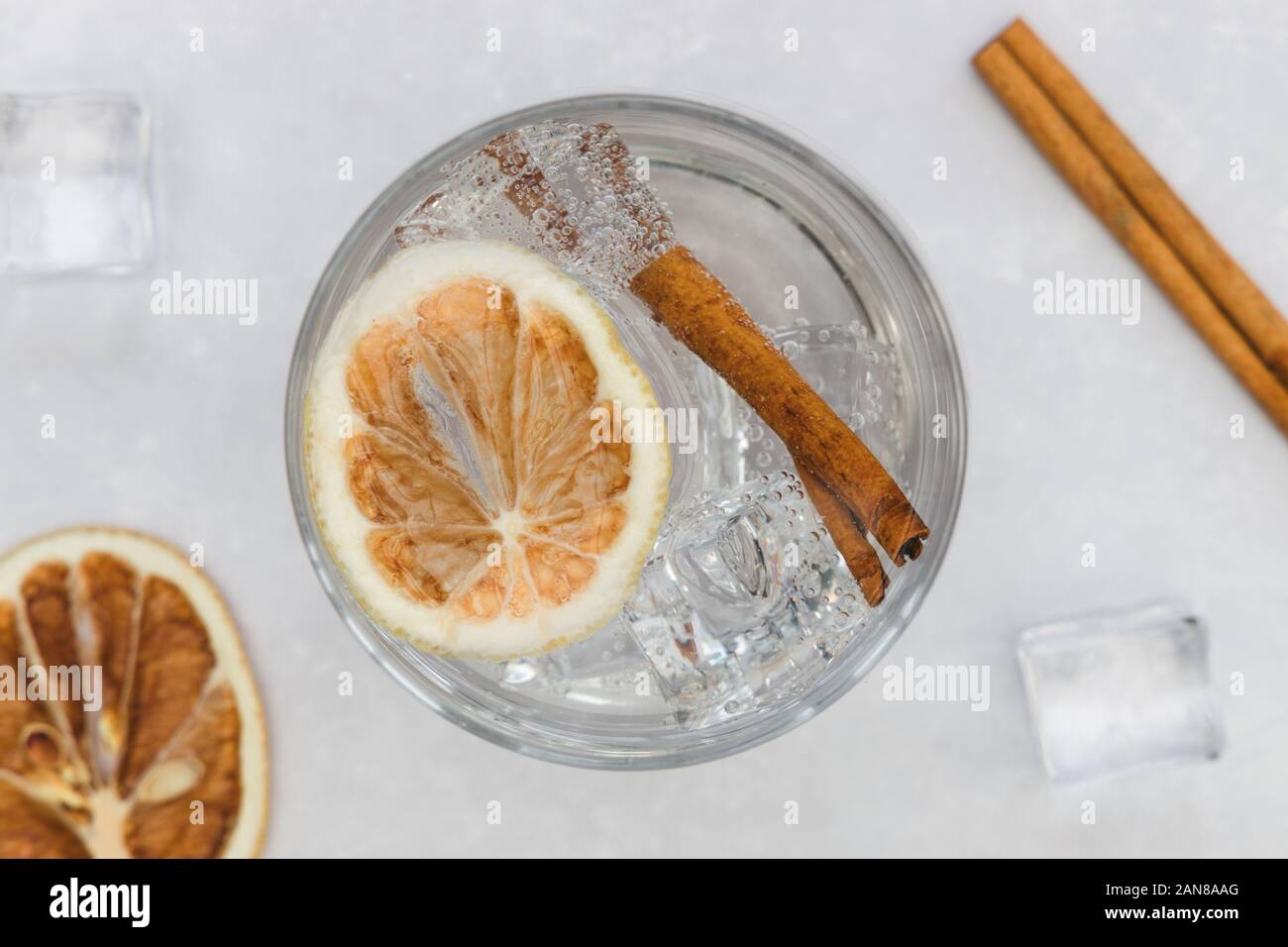 Gin tonic vodka soda cocktail drink in glass with ice cinnamon, top view on white background