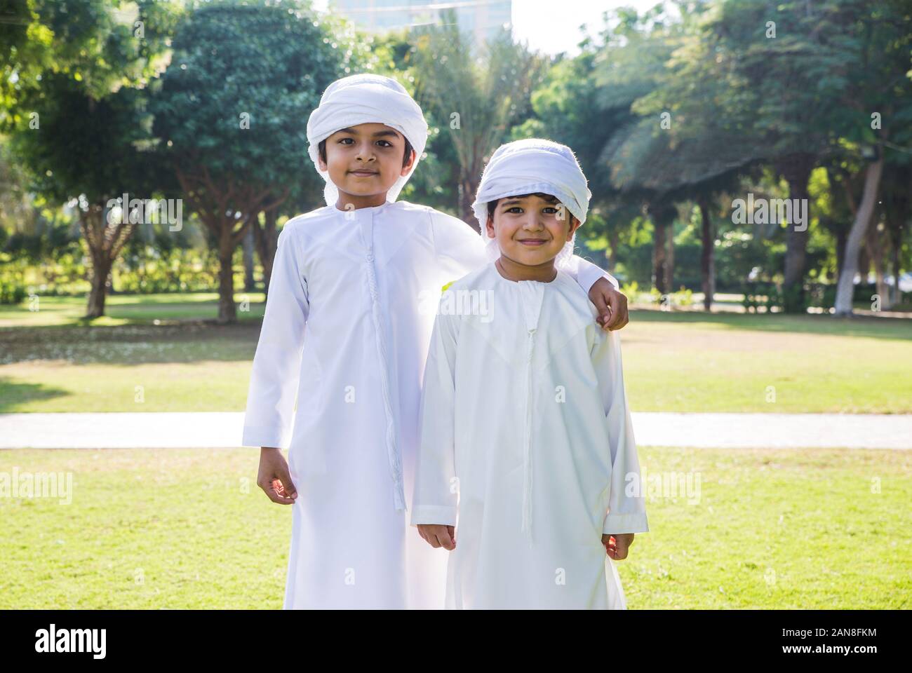 Children playing together in Dubai in the park. Group of kids wearing  traditional kandura white dress from arab emirates Stock Photo - Alamy