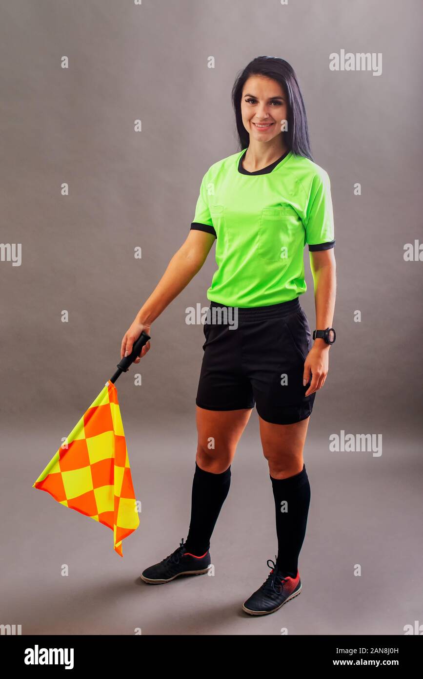 Beautiful Soccer Referee with flag in hand looking at camera and smile Stock Photo