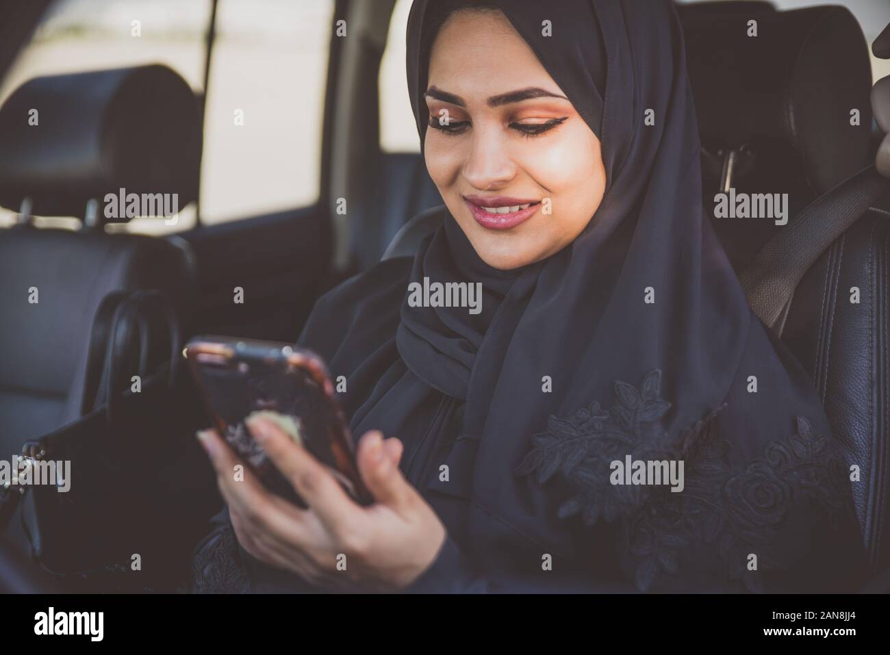 Beautiful woman in Dubai wearing abaya traditional female dress driving the car. Concept about uae and women rights Stock Photo