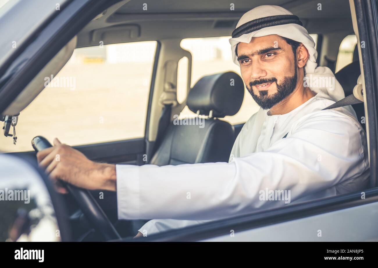 Handsome man with uae traditional outfit driving in Dubai. Middle eastern man with kandura in the car Stock Photo