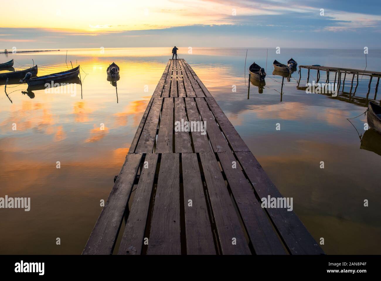 beautiful sunrise over water and silhouette of fishing boat Stock Photo ...