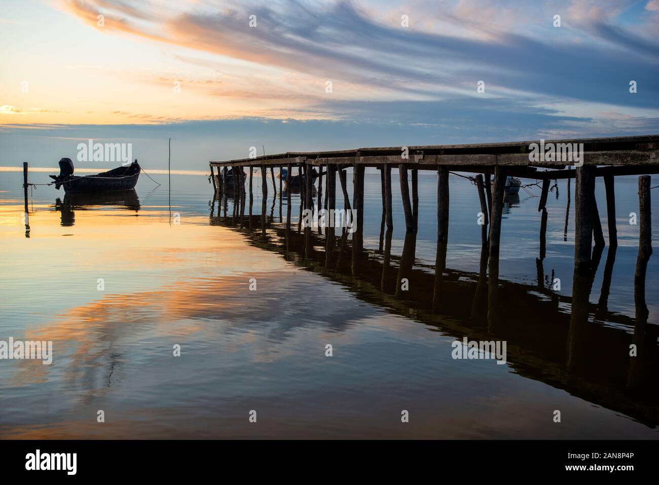 beautiful sunrise over water and silhouette of fishing boat Stock Photo ...