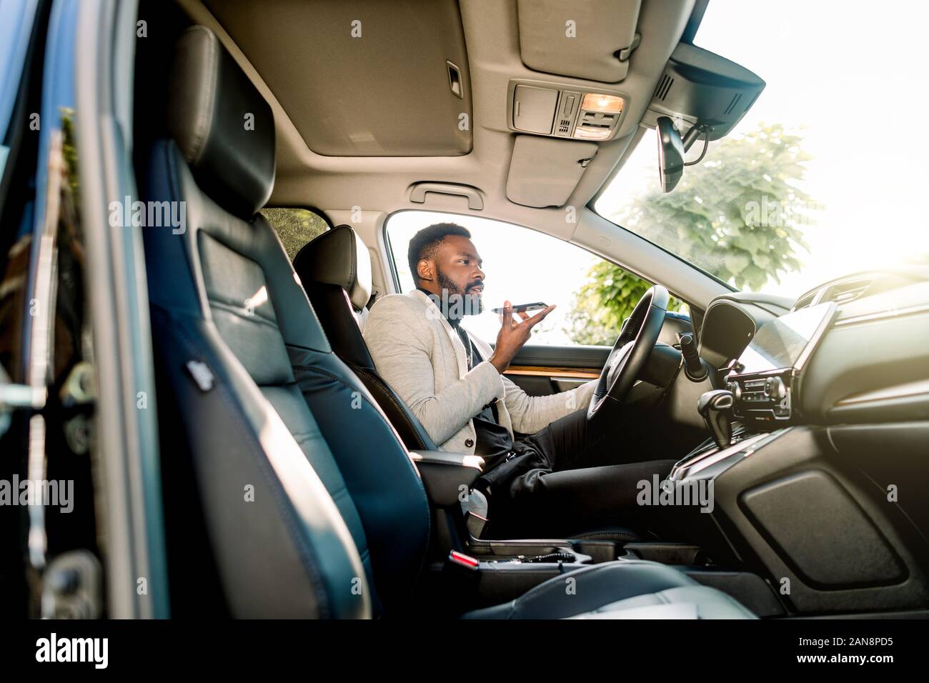 Young successful African American businessman talking on speakerphone