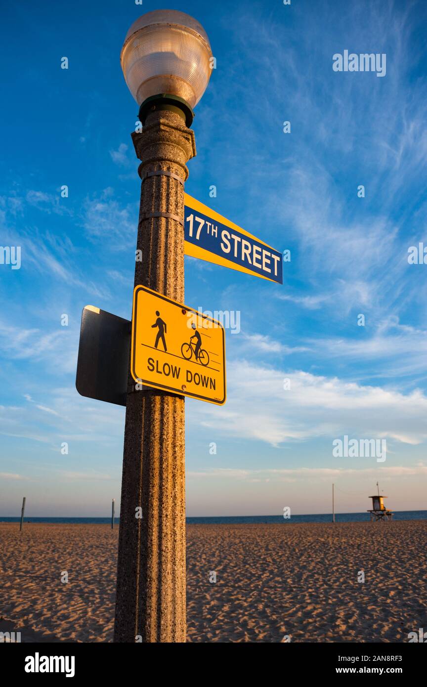 Newport beach street sign and lamp lit up by sunset light, 17th street sign with pedestrian and cycle path sign Stock Photo