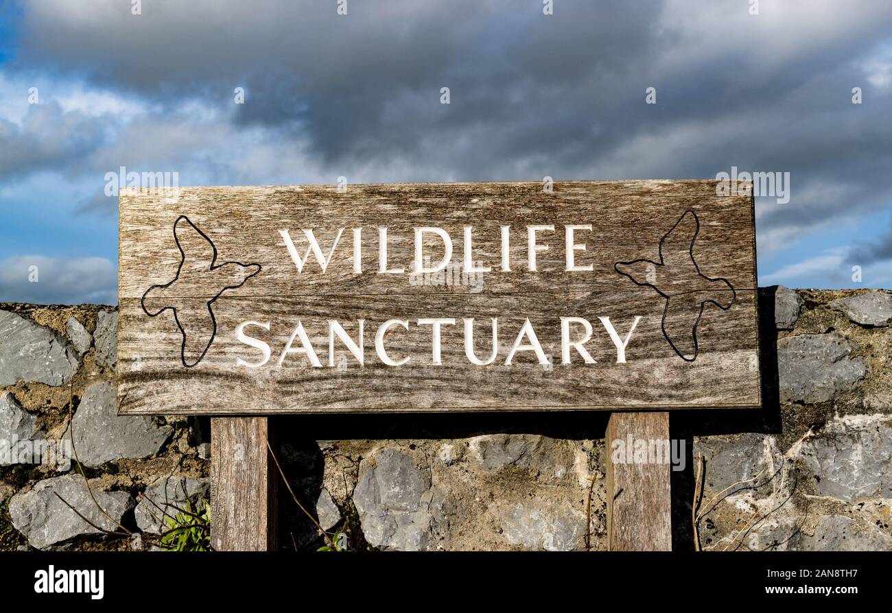 Wildlife sactuary sign outside stone wall barrier Stock Photo